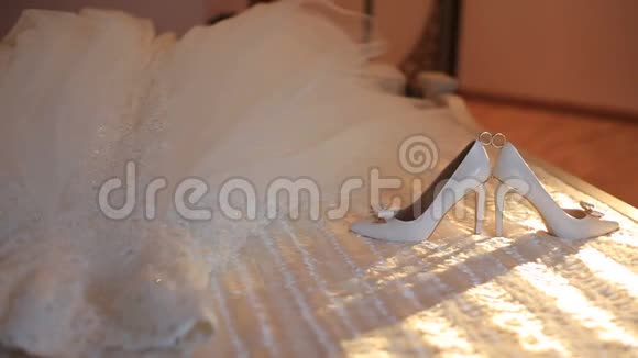 新娘海厄尔之间婚戒的近景躺在床上的礼服附近移动的阳光视频的预览图
