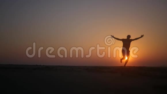 一个人沿着海滩奔跑在夕阳下双手向上旋转高清1920x1080慢动作视频的预览图