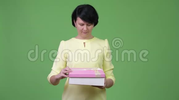 一位漂亮的女商人打开礼品盒时显得很惊讶视频的预览图