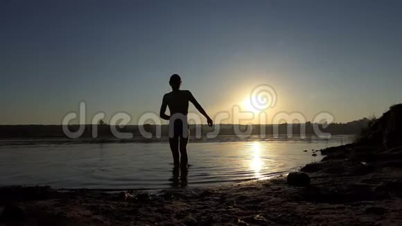 快乐的年轻人在日落时分在湖中跳迪斯科视频的预览图