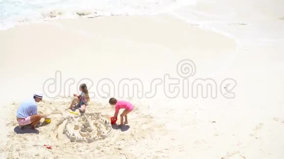 从上面看到父亲和小女儿在热带海滩上做沙堡视频的预览图