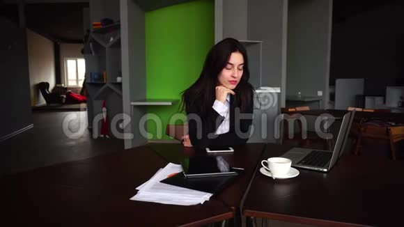一幅美丽的女秘书的肖像她在电脑工作时摆姿势看着远处坐在桌子旁视频的预览图