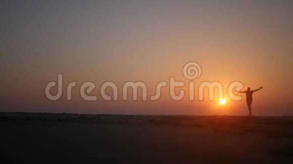 一个人沿着海滩奔跑举起双手迎着夕阳高清1920x1080慢动作视频的预览图