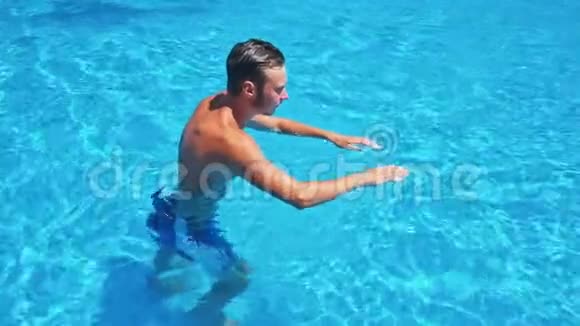 阳光明媚的一天男人在游泳池里散步视频的预览图