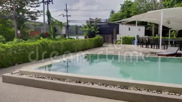 度假酒店游泳池全景女子日光浴附近躺椅视频的预览图