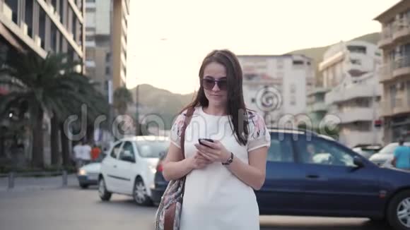 年轻女性使用智能手机背包旅行时尚休闲的户外生活方式画像视频的预览图