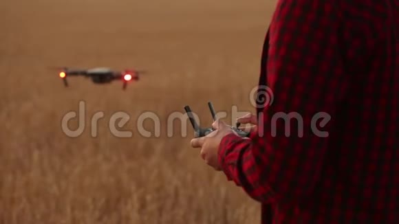 农夫双手握着遥控器四架直升机在后台飞行无人机在后面徘徊视频的预览图