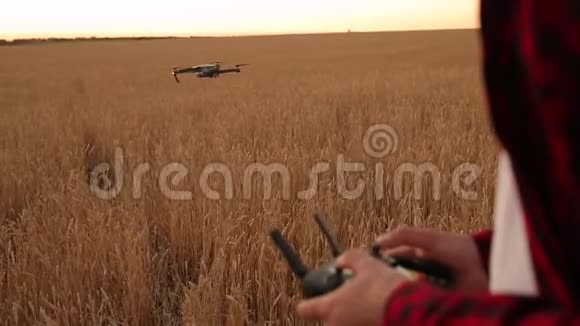 农夫双手握着遥控器四架直升机在后台飞行无人机在后面徘徊视频的预览图