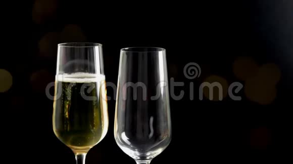 在黑色和bokeh背景下用金色气泡填充香槟的长笛黄金豪华假日快乐的概念视频的预览图