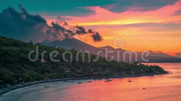 壮观的日落时间在杰梅鲁克湾可以看到巴厘岛阿贡火山上方的海洋和云层视频的预览图