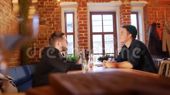 两个人坐在餐厅的桌子旁视频的预览图