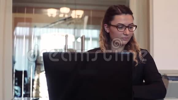肖像商务女性在办公室工作桌旁坐着一台移动电脑视频的预览图
