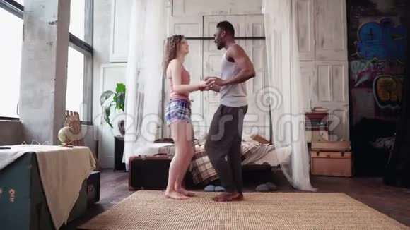 年轻的多种族夫妇早上在灯光公寓里跳舞非洲男人和欧洲女人在一起玩得很开心视频的预览图