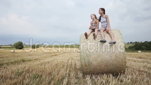 两个女孩坐在干草堆上视频的预览图