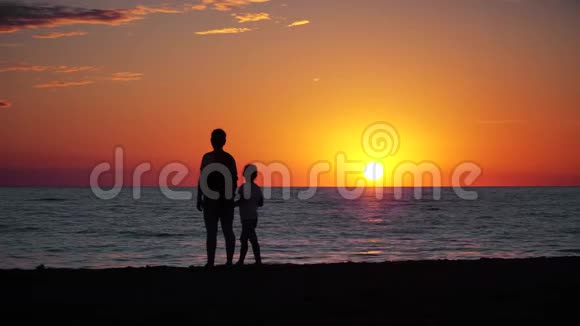 母亲和孩子在海上剪影和日落视频的预览图