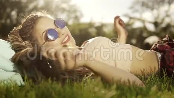 时髦的时髦女孩害怕在公园的草地上放松夏天的生活方式画像上躺着时髦女人视频的预览图