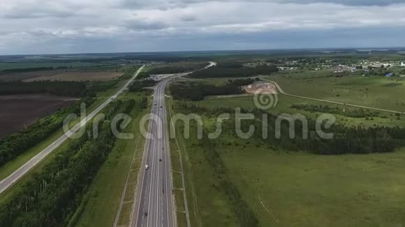 空中俯瞰宽阔的公路和骑行车绿色的乡村田野视频的预览图