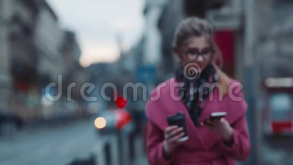 漂亮的年轻女人穿着优雅的外表走在拥挤的城市街道上带着一杯咖啡和电话忙忙忙忙忙忙视频的预览图
