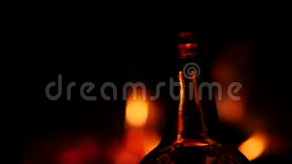 啤酒瓶在黑暗中的火背景上棕色玻璃上的火焰游戏4K视频的预览图