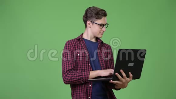 年轻英俊的青少年书呆子用笔记本电脑视频的预览图