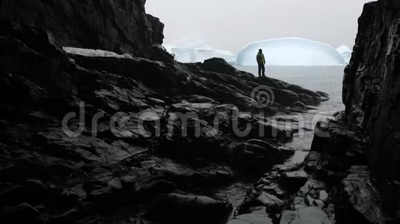 游客站在海湾和冰山的背景下的岩石上安德列夫视频的预览图