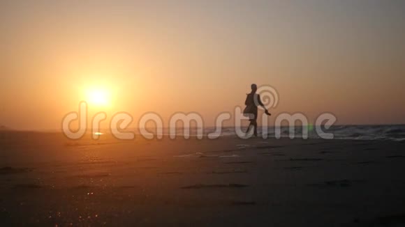 独自走在海边的沙滩上在金色的阳光下欣赏美丽的日落高清1920x1080缓慢的视频的预览图