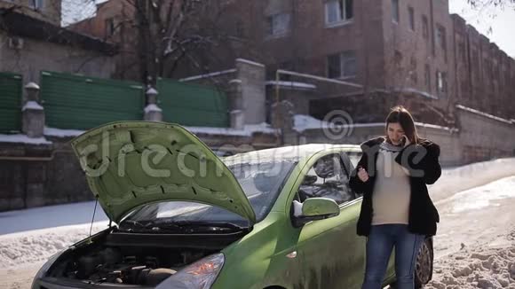 一个怀孕的女孩在一辆破车附近用电话求救视频的预览图