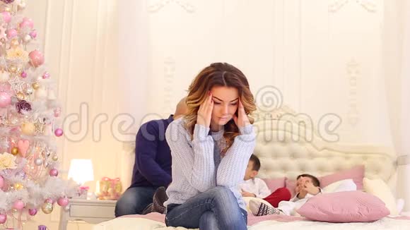 一幅美丽的女人的肖像她思考着家庭的未来坐在床上以丈夫和丈夫为背景视频的预览图