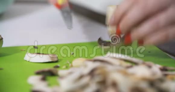 家庭主妇在厨房里切蘑菇做饭视频的预览图