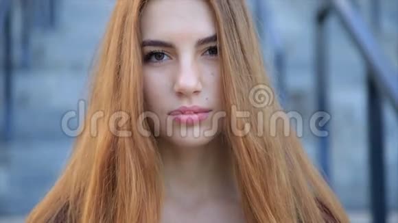 美丽的愤怒悲伤的年轻女孩的肖像留着长长的红色头发视频的预览图