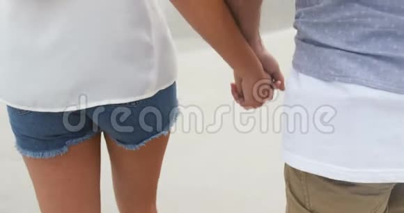 海滩上手牵着手走4k的夫妇中间部分视频的预览图
