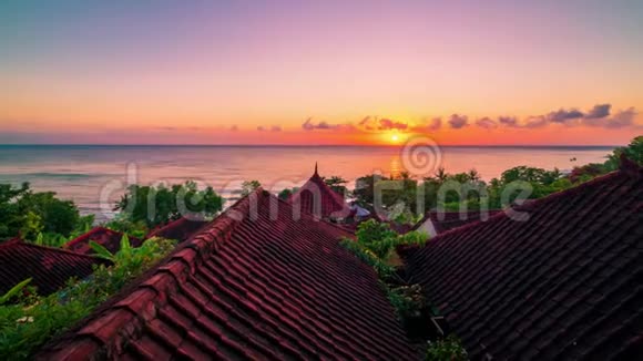在巴厘岛的阿米德岛上有热带树木的屋顶平房是海洋的背景视频的预览图