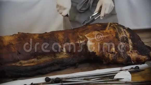 厨师用刀把烤肉切成薄片在火上烤猪视频的预览图