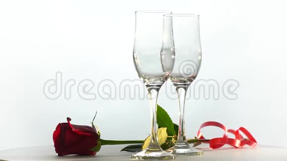 台上有两个玻璃杯和一朵玫瑰视频的预览图