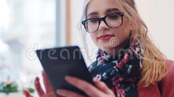 使用便携式上网设备为一个年轻女孩提供自然化妆和时尚眼镜的近距离观看视频的预览图
