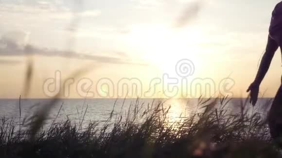 女孩走在靠近大海的海滩上裙子在风中展开背景是天空和视频的预览图