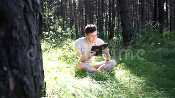 人在绿色的夏日森林里看书视频的预览图