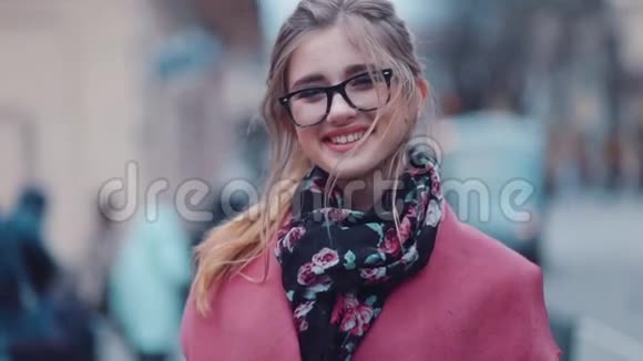 旋转近景一个年轻女孩可爱地微笑着走向相机快乐的表情时尚的外表积极正面视频的预览图