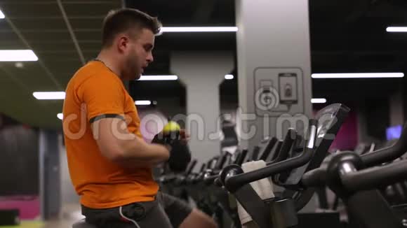 健身男在健身房骑运动自行车锻炼身体视频的预览图