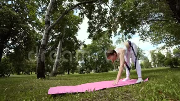 女孩在冥想专业瑜伽练习在公园做呼吸练习年轻的黑发女人练习瑜伽视频的预览图