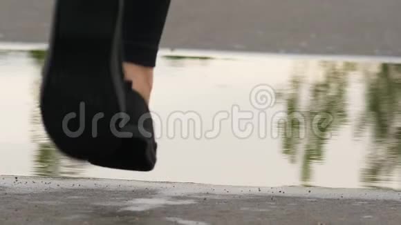女人的腿在水坑上奔跑动作缓慢视频的预览图