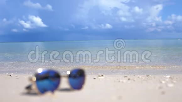 旅游度假理念模糊的蓝色太阳镜在一个集中的白色海滩拉兹尔绿松石海视频的预览图