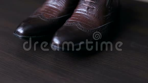 男人的特写木桌上的棕色鞋子视频的预览图