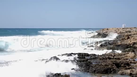 强烈的海浪撞击岩石海滩海浪拍打着岩石海滩视频的预览图