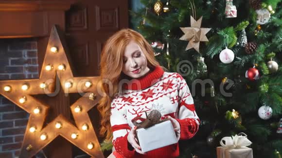 漂亮的红发女孩拿着圣诞礼物微笑着视频的预览图