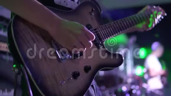 音乐会上一个男子在舞台上演奏电吉他的特写镜头慢镜头视频的预览图