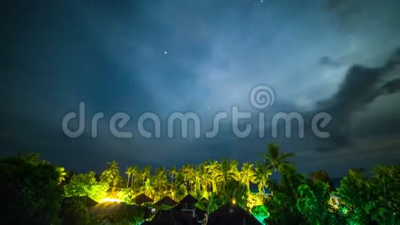 印度尼西亚巴厘岛热带雨林棕榈树和平房上空星光闪烁的夜空视频的预览图