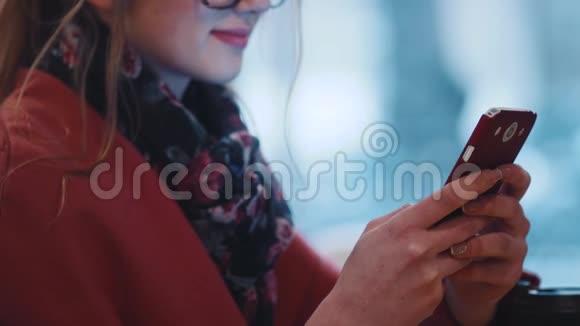 近距离观看一位戴着书呆子眼镜的年轻女士高兴地使用她的手机在线使用wifi视频的预览图