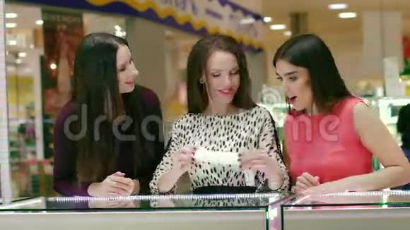 三个穿着漂亮裙子的漂亮女人在珠宝店看配饰视频的预览图