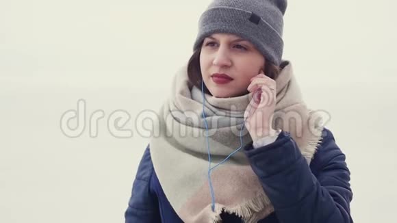 一个年轻漂亮的女人在户外散步时听音乐跳舞视频的预览图